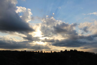 Silhouette landscape against cloudy sky