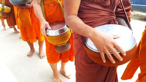 High angle view of monks standing with containers on street