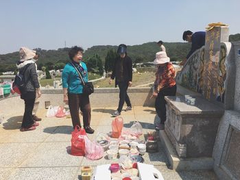 People standing on mountain against clear sky