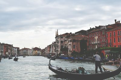 Boats in river with buildings in background