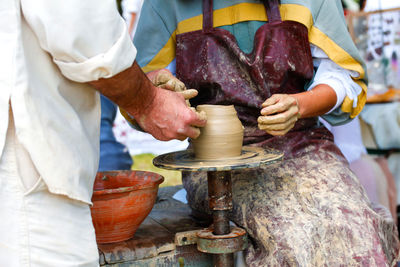 Woman potter teaching the art of pot making. women working on potters wheel making clay objects 