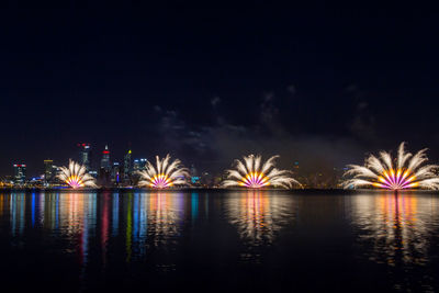 View of firework display over river at night