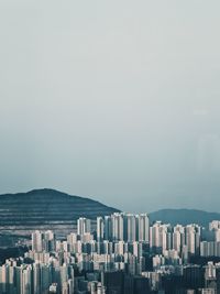 Cityscape by sea against clear sky