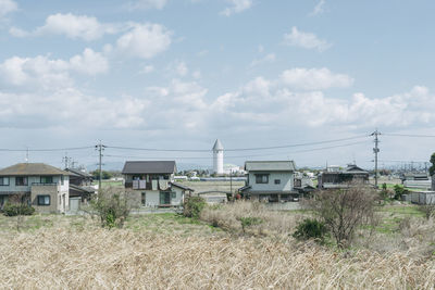 Houses on field against sky