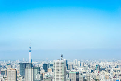 Buildings in city against clear blue sky