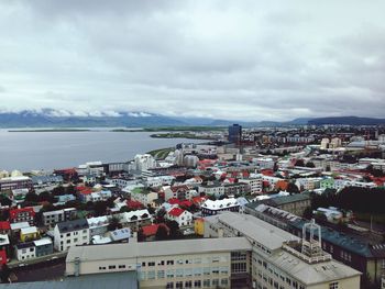 Cityscape by sea against sky