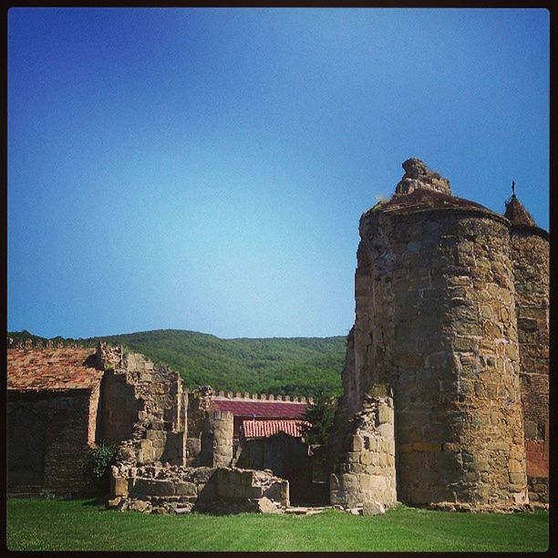 architecture, built structure, clear sky, building exterior, history, transfer print, old ruin, blue, grass, ancient, old, auto post production filter, copy space, the past, stone wall, landscape, ancient civilization, ruined, abandoned, sky