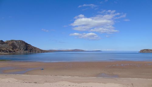 Scenic view of beach against blue sky