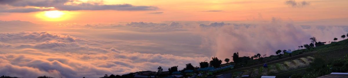 Panoramic view of buildings against cloudy sky during sunset