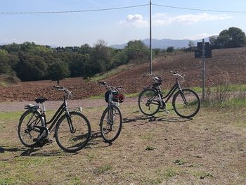 Bicycles on field against sky