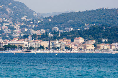 Scenic view of sea by town against sky