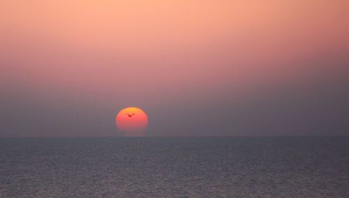 Scenic view of sea against orange sky