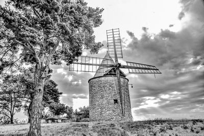 Traditional windmill on field against sky