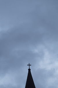 Low angle view of weather vane against sky