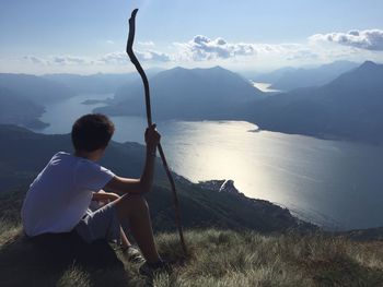 Rear view of man sitting on mountain