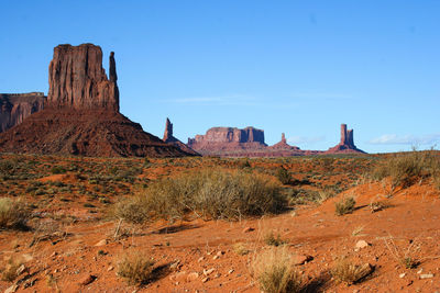 Rock formations on landscape against blue sky