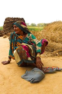Midsection of woman sitting on field