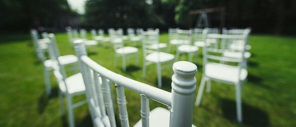 White chairs arranged on grassy field at yard