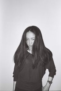 Young woman standing against white background