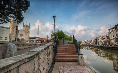 Bridge over canal amidst buildings against sky