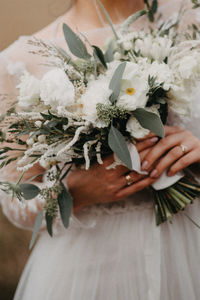 Midsection of woman bride holding flower bouquet