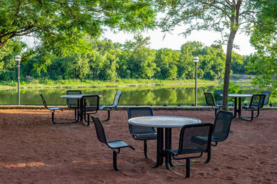 Empty chairs and table in park