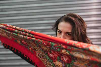 Portrait of woman with scarf against face standing outdoors