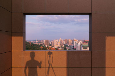 Shadow of man with tripod on wall in building