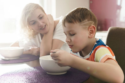 Close-up of boy eating food at home