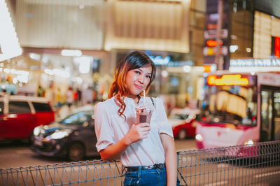 Portrait of woman standing on street in city