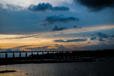 Scenic view of silhouette beach against sky during sunset