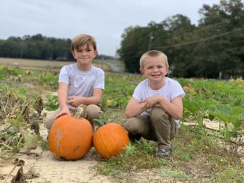 Portrait of happy boy with pumpkins on field