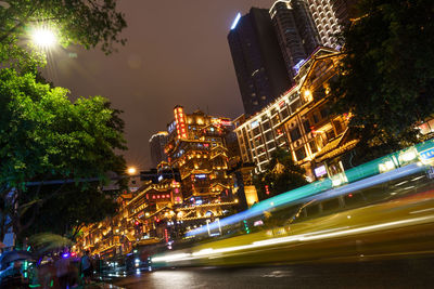 Illuminated buildings against sky at night