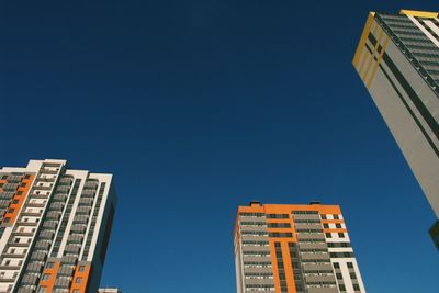 Low angle view of buildings against clear blue sky