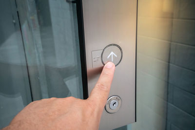 Close-up of hand holding camera against door