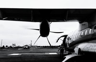 Airplane on airport runway against sky