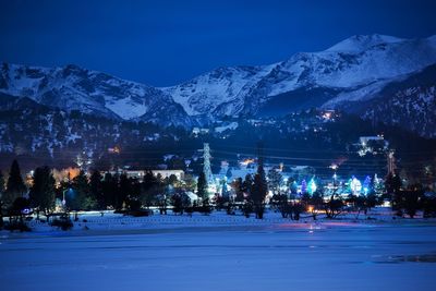 Scenic view of snow covered mountains against sky at night