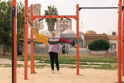 Rear view of woman swinging at playground