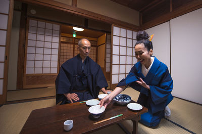 Man holding coffee while sitting on table