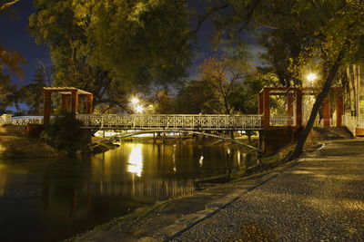 Bridge over river against sky at night