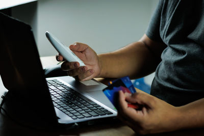 Midsection of woman using laptop