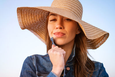 Portrait of a smiling young woman against sky