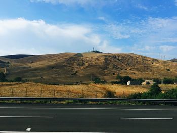 Road leading towards mountain against sky