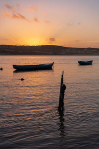 Fishing boats on a river sea at sunset in foz do arelho, portugal