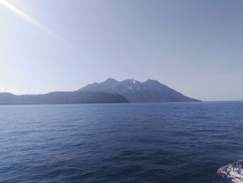 Scenic view of sea and mountains against clear sky