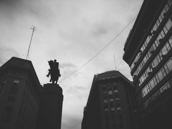 Low angle view of statue in city against sky