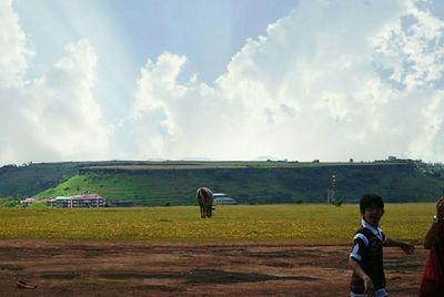 Boy on field against sky