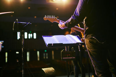 Midsection of man playing guitar