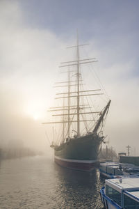 Germany, hamburg, rickmer rickmers ship moored in harbor at foggy sunrise