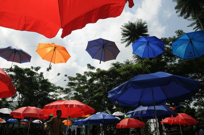 Low angle view of umbrellas hanging against sky